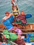 Three canoes full of native women and their colorful art.  More canoes arrive every minute!!  
