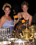 Cherie and Jean surrounded by champagne and trophies.