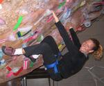 Cherie dangles upside down at an indoor rock climbing gym.  This is yoga for the adventurous!