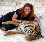 Cherie cuddles with a tiger at a forest monastery in Thailand.