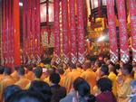 The room is packed with monks and Buddhist followers.