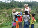 Children huddle around Margaret.  They are drawn by her blonde hair and tourist dollars.