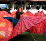 Cherie tucked in the colorful shade of hand-made bamboo parasols.