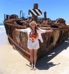 Cherie in front of a washed-up rusted ship wreck on Fraser Island, off the east coast of Australia.
