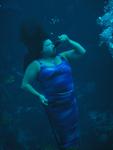 A former mermaid demonstrates drinking under water. *Photo by John Athanason
