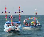 Balloon crosses and paper flowers adorn the fishing vessels.